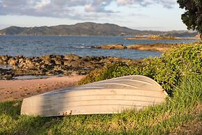 Cable Bay Stays – Golden Sand and Driftwood Beachfront Accommodation
